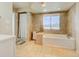 Modern bathroom featuring a soaking tub, tiled walls, and a window with natural light at 18045 Sunburst Dr, Monument, CO 80132