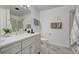 Bright bathroom features a double vanity, framed mirror, tile floors, and a walk-in shower with glass doors at 18045 Sunburst Dr, Monument, CO 80132