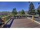 Spacious deck with wood railings and panoramic views of the lush green landscape and mountains at 18045 Sunburst Dr, Monument, CO 80132