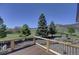 Outdoor deck with wooden railings, showcasing beautiful views of the green landscape and mountains at 18045 Sunburst Dr, Monument, CO 80132