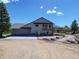 Charming home featuring a spacious garage, deck, and landscaped yard with stone accents under a clear blue sky at 18045 Sunburst Dr, Monument, CO 80132