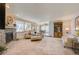 Expansive living room boasts a stone fireplace, large windows, and an open layout to the dining area at 18045 Sunburst Dr, Monument, CO 80132