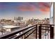 Balcony with iron railing offering a view of a city skyline under a dynamic sky at 2240 N Clay St # 501, Denver, CO 80211