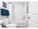 Bright, white bathroom with a shower-tub combo, tile surround, and decorative towels on the towel bar at 2240 N Clay St # 501, Denver, CO 80211