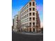 Exterior corner facade of a condo complex with tan brick, multiple balconies, and street level shops at 2240 N Clay St # 501, Denver, CO 80211