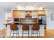 Well-lit kitchen with central island, stainless appliances, light wood cabinetry, and hardwood floors at 2240 N Clay St # 501, Denver, CO 80211