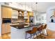 Stylish kitchen featuring light wood cabinets, sleek island with seating, and stainless-steel appliances at 2240 N Clay St # 501, Denver, CO 80211