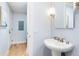 Stylish powder room with a pedestal sink, decorative lighting, and hardwood floors leading to other rooms at 2240 N Clay St # 501, Denver, CO 80211
