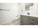 This modern bathroom features stylish gray vanity, illuminated mirror, and neutral tile flooring at 2809 Syracuse Ct # 129, Denver, CO 80238