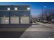 Rear view of the blue townhome showing garage doors and parking for tenants at 2809 Syracuse Ct # 129, Denver, CO 80238