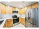 Modern kitchen featuring stainless steel appliances, light wood cabinets, and stylish tile backsplash at 2809 Syracuse Ct # 129, Denver, CO 80238