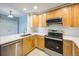 Modern kitchen featuring stainless steel appliances, light wood cabinets, and stylish tile backsplash at 2809 Syracuse Ct # 129, Denver, CO 80238