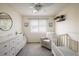 Charming Bedroom with a white crib, dresser, comfortable chair and bright natural light at 1009 Monarch Way, Superior, CO 80027