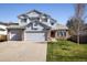 Inviting two-story home with a neatly manicured lawn, a two-car garage, and a welcoming entrance at 1009 Monarch Way, Superior, CO 80027