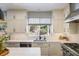 Bright kitchen featuring white cabinets, modern appliances, quartz countertops, and view to lush backyard at 1009 Monarch Way, Superior, CO 80027
