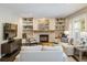 Inviting living room with stone fireplace, floating shelves, and large windows, creating a warm and comfortable space at 1009 Monarch Way, Superior, CO 80027