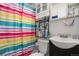 Bathroom with tile walls, colorful shower curtain, and vanity storage for organization at 1910 S King St, Denver, CO 80219