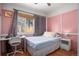 Cozy bedroom with pink walls, hardwood floors, and a window providing ample natural light at 1910 S King St, Denver, CO 80219