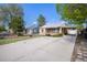 View of a one-story home and long driveway leading to a covered parking area and a detached garage at 1910 S King St, Denver, CO 80219