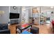 Open-concept living room with hardwood floors, a television, and a view into the dining area and kitchen at 1910 S King St, Denver, CO 80219