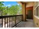 Cozy balcony featuring dark railing, outdoor access door and a view of the surrounding greenery at 8467 Canyon Rim Cir # 302, Englewood, CO 80112
