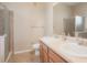 Bathroom featuring double sinks, wood cabinets, framed mirrors, and glass enclosed shower at 8467 Canyon Rim Cir # 302, Englewood, CO 80112