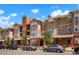 A multi-story condo building showcasing a beige facade, brick accents, and well-maintained landscaping at 8467 Canyon Rim Cir # 302, Englewood, CO 80112