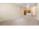 Bright living room with plush carpet, neutral paint, and partial view of adjacent kitchen area at 8467 Canyon Rim Cir # 302, Englewood, CO 80112