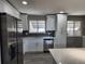 This kitchen showcases white cabinets, quartz countertops, stainless steel appliances, and gray plank flooring at 8954 N Carr Cir, Broomfield, CO 80021