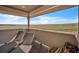 Outdoor covered balcony features seating and views of open land at 15125 Spring Valley Rd, Larkspur, CO 80118