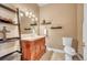 This half bath has a wooden sink cabinet, decorative shelves, and tiled floor at 15125 Spring Valley Rd, Larkspur, CO 80118