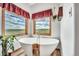 Soaking tub with chrome fixtures is situated under two view-framing windows at 15125 Spring Valley Rd, Larkspur, CO 80118