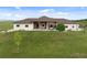 Charming single-story home featuring a stone facade, covered porch and spacious green lawn at 15125 Spring Valley Rd, Larkspur, CO 80118