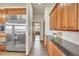 Hallway with wood floors, built-in cabinets and stainless refrigerator at 15125 Spring Valley Rd, Larkspur, CO 80118