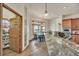Kitchen with granite countertops, wood cabinetry, and views into the dining room at 15125 Spring Valley Rd, Larkspur, CO 80118