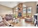 The living room has a stone fireplace and vaulted ceilings, with many windows framing the outside views at 15125 Spring Valley Rd, Larkspur, CO 80118