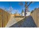 Backyard featuring a wooden fence, grass, and gravel, providing a private outdoor space at 8985 Lander St, Westminster, CO 80031