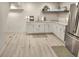 Charming kitchenette features white cabinetry, a stainless steel refrigerator, and stylish decor for added convenience at 8985 Lander St, Westminster, CO 80031