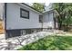 Side view of home with concrete patio and lush green lawn in the partially shaded backyard at 4818 Bryant St, Denver, CO 80221