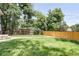 Spacious fenced backyard with green grass and mature trees providing ample shade at 4818 Bryant St, Denver, CO 80221
