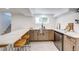 Basement bar with light wood cabinets, barstool seating, mini-fridge, and a white countertop at 4818 Bryant St, Denver, CO 80221