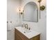 Stylish bathroom vanity with a modern sink, elegant lighting fixtures, and a sleek, arched mirror at 4818 Bryant St, Denver, CO 80221