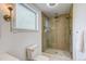 Modern bathroom featuring a glass-enclosed shower with dual shower heads and decorative wall-mounted lights at 4818 Bryant St, Denver, CO 80221