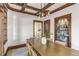 Charming dining room boasts wood beam ceiling, custom built-in bar, and ample natural light at 4818 Bryant St, Denver, CO 80221