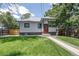 Charming exterior with walkway leading to a red door and well-maintained lawn at 4818 Bryant St, Denver, CO 80221