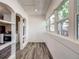 Bright sunroom with wood floors and archways leading to the kitchen; natural light and a view at 4818 Bryant St, Denver, CO 80221