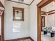Hallway featuring white tiled walls and wood trim leading into the living room at 4818 Bryant St, Denver, CO 80221