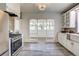 Modern kitchen with stainless steel appliances, stone backsplash, white cabinetry, and tile flooring at 4818 Bryant St, Denver, CO 80221
