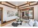 Bright living room with hardwood floors, wooden beams, modern art, and natural light streaming through the windows at 4818 Bryant St, Denver, CO 80221