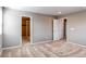 Spacious bedroom with neutral carpeting and doors leading to bathroom and hallway at 27615 E Archer Ave, Aurora, CO 80018